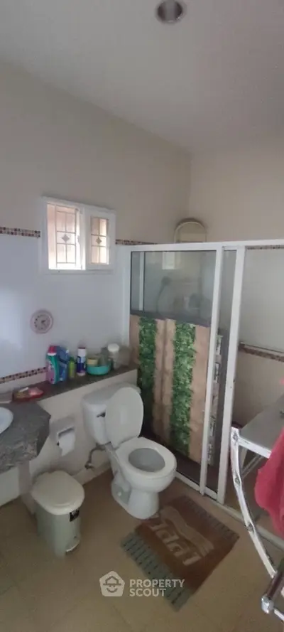 Cozy bathroom with shower and modern fixtures in a well-lit space.