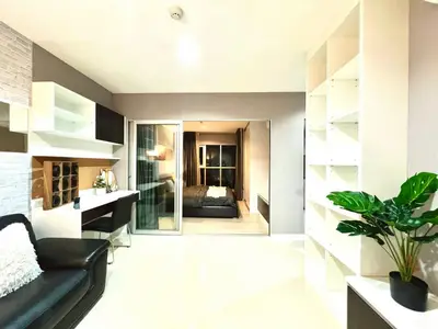 Modern open-plan living room with sleek black sofa and stylish shelving