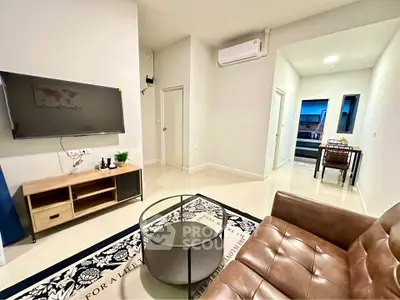 Modern living room with sleek furniture and wall-mounted TV in a cozy apartment.