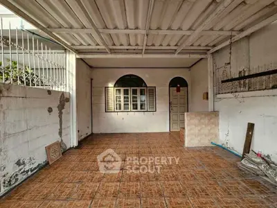 Spacious tiled garage with window and door access, ideal for storage or parking.