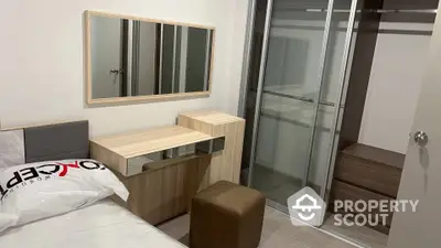 Modern bedroom with sleek furniture and built-in wardrobe, featuring a large mirror and ample storage space, ideal for urban living.