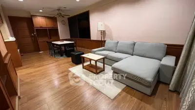 Spacious living room with modern furniture and wooden flooring in a cozy apartment.