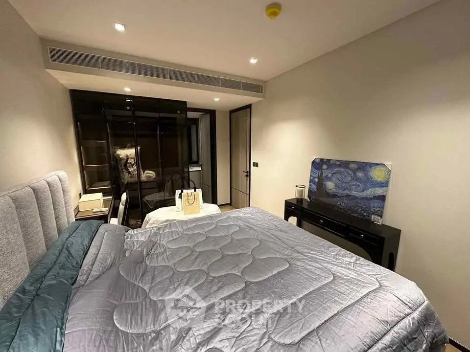 Luxurious bedroom with modern decor and cozy bedding in upscale apartment.