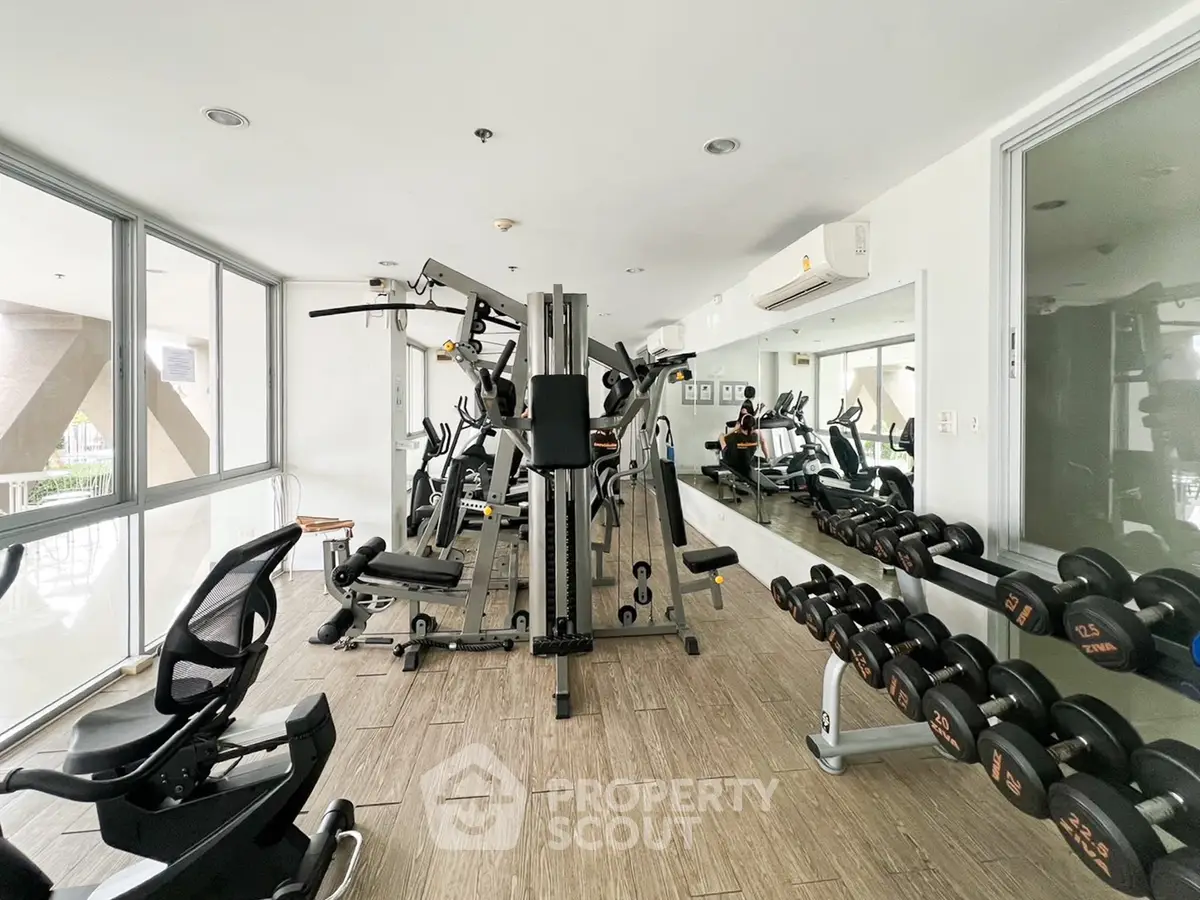Modern gym with state-of-the-art equipment and mirrored walls in a residential building.