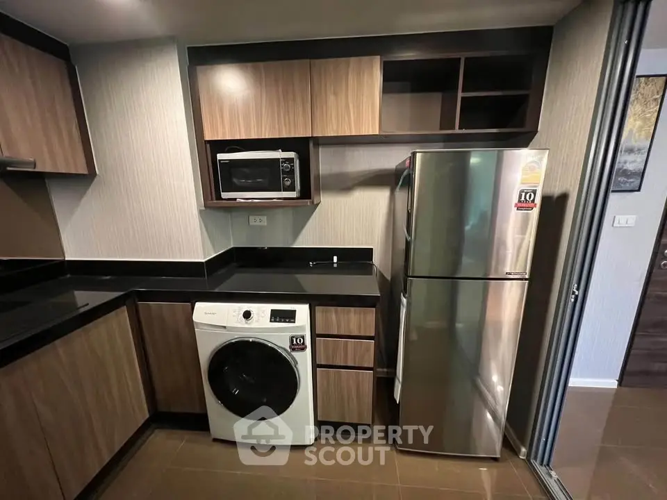 Modern kitchen with sleek appliances and stylish cabinetry in a contemporary apartment.