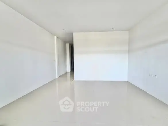 Spacious empty room with white walls and glossy floor, ideal for customization.