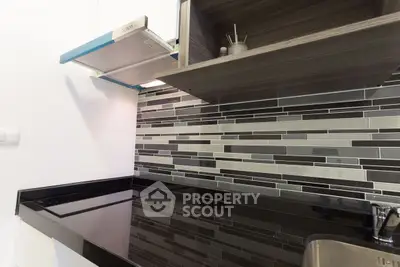 Modern kitchen with sleek black countertop and stylish backsplash