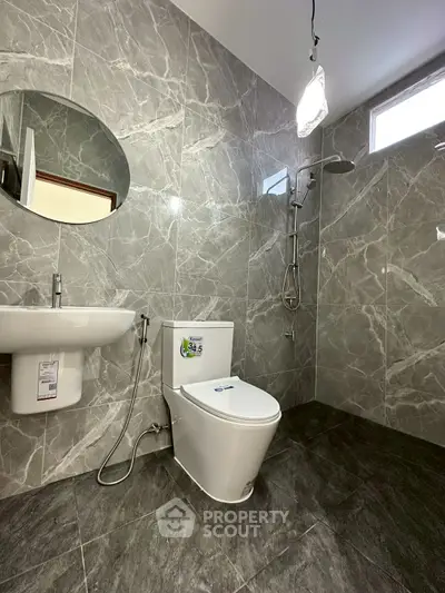 Modern bathroom with sleek gray marble tiles and contemporary fixtures.