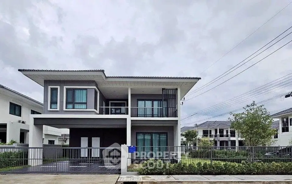 Modern two-story house with sleek design and spacious balcony in a serene neighborhood.