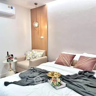 Cozy bedroom with modern decor and elegant lighting, featuring a comfortable armchair and stylish bedding.