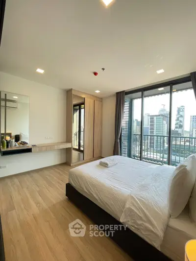 Spacious bedroom with city view and large windows in modern apartment