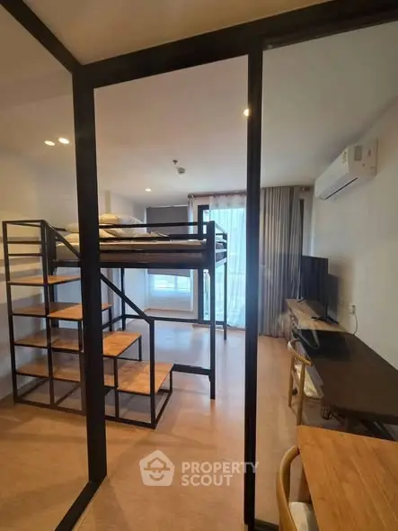 Modern studio apartment with loft bed and workspace, featuring large windows and sleek design.