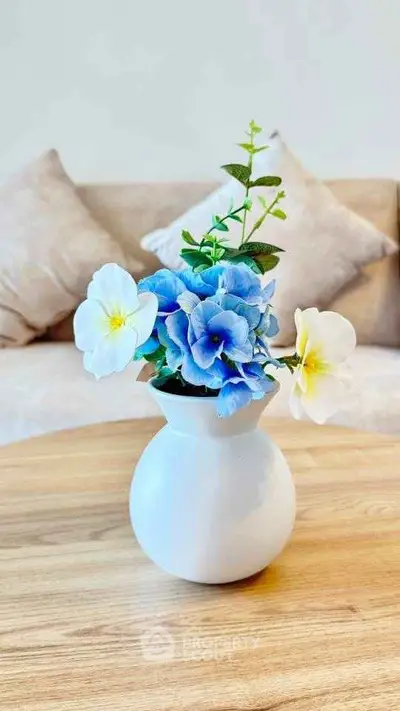 Elegant living room with stylish vase and floral arrangement on wooden table.