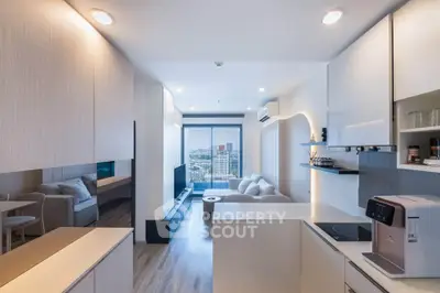 Modern open-layout living room with kitchen, featuring sleek design and city view.