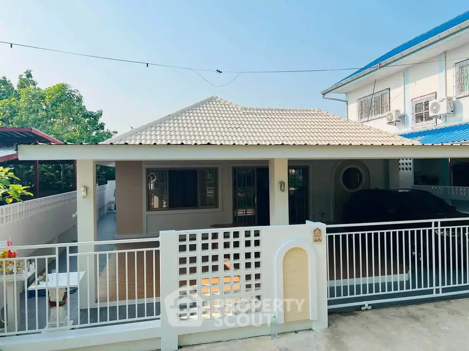 Charming single-story house with a tiled roof and gated entrance, perfect for cozy living.
