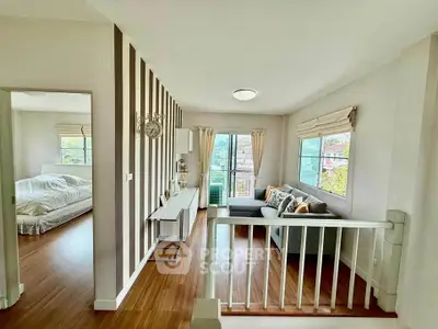 Spacious living room with stylish decor and natural light, adjacent to a cozy bedroom, perfect for modern living.