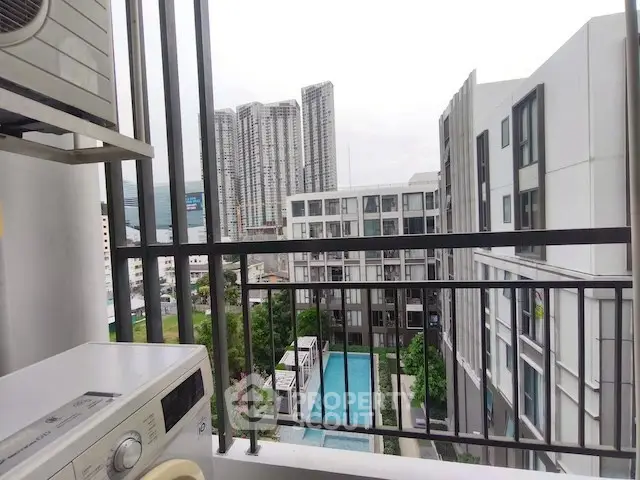 Modern urban apartment view with pool and cityscape from balcony.