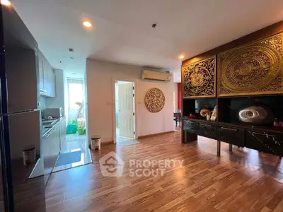 Spacious living area with elegant wooden flooring and artistic wall decor in modern apartment.