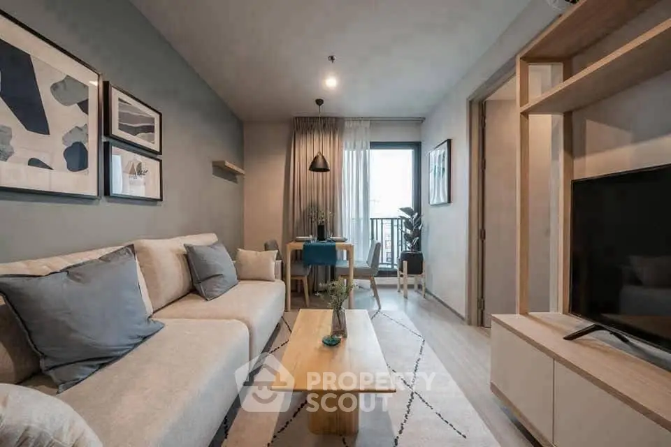 Modern living room with stylish decor and natural light, featuring a cozy sofa and a sleek TV unit.