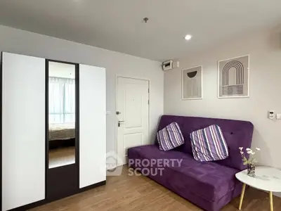 Modern living room with purple sofa and stylish decor in a cozy apartment.