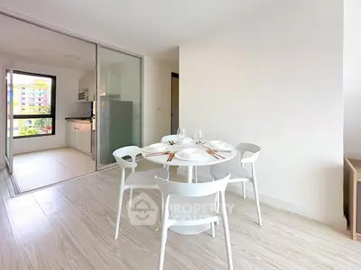Modern dining area with white furniture and open kitchen layout