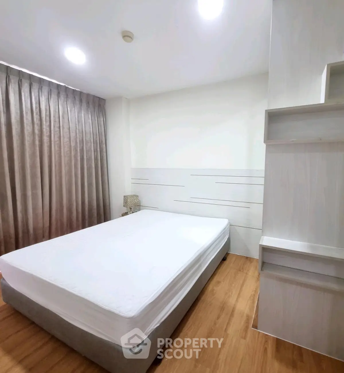 Modern minimalist bedroom with wooden flooring and stylish lighting