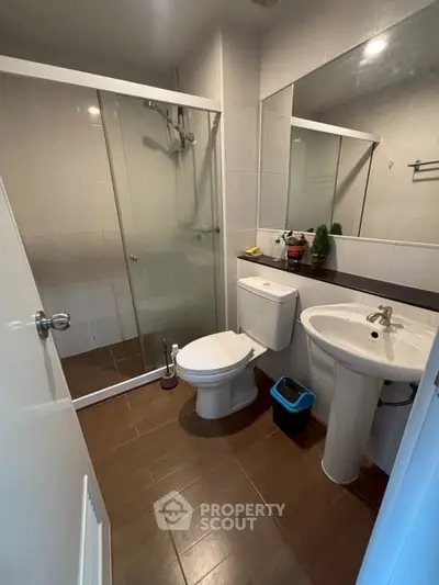 Modern bathroom with glass shower, sleek fixtures, and stylish decor