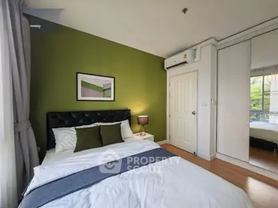 Modern bedroom with green accent wall and mirrored closet doors