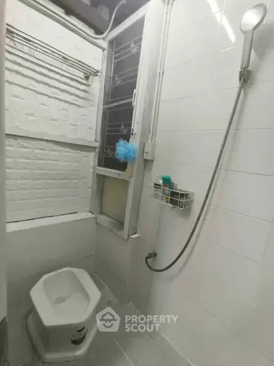 Compact bathroom with shower and unique toilet design, ideal for space-saving solutions.