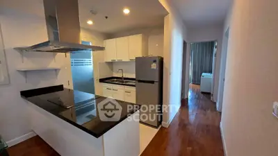 Modern kitchen with sleek design and hardwood floors in a stylish apartment.