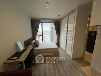Modern bedroom with city view, featuring sleek furniture and ample natural light.
