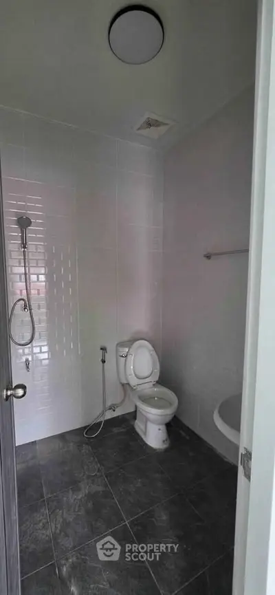 Modern bathroom with sleek tiles and essential fixtures in a contemporary home.
