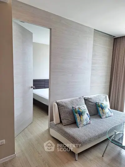 Modern living room with stylish sofa and open door to bedroom