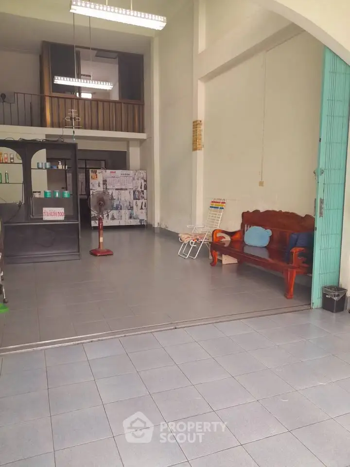 Spacious open-plan living area with high ceilings and mezzanine, ideal for versatile use.