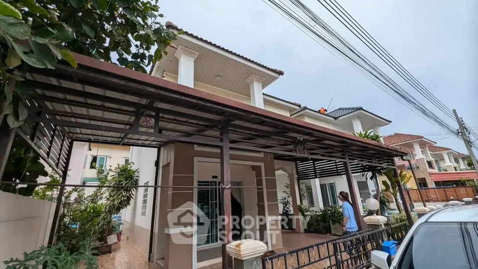 Charming two-story house with covered carport and lush greenery in a serene neighborhood.