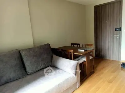 Cozy living room with wooden flooring and compact dining area, perfect for modern living.