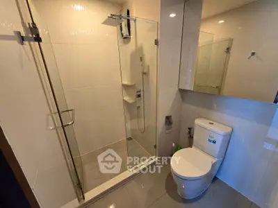 Modern bathroom with glass shower and sleek fixtures in a contemporary home.