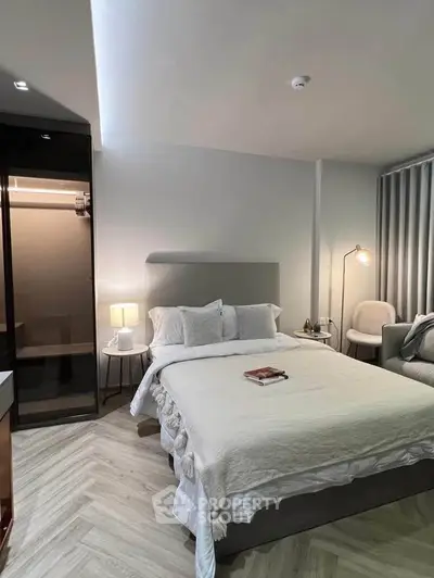 Modern bedroom with elegant decor and cozy lighting, featuring a comfortable bed and stylish furniture.