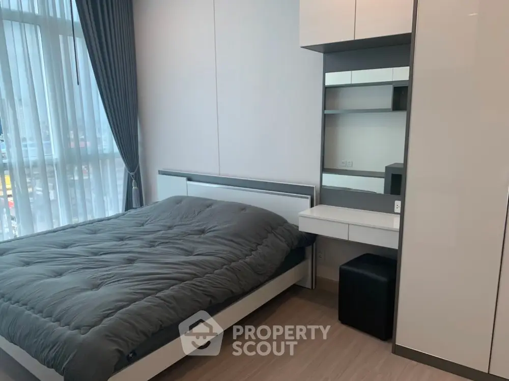 Modern bedroom with sleek design and large window for natural light.