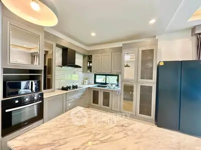Luxurious modern kitchen with marble countertops and sleek appliances in a stylish home.