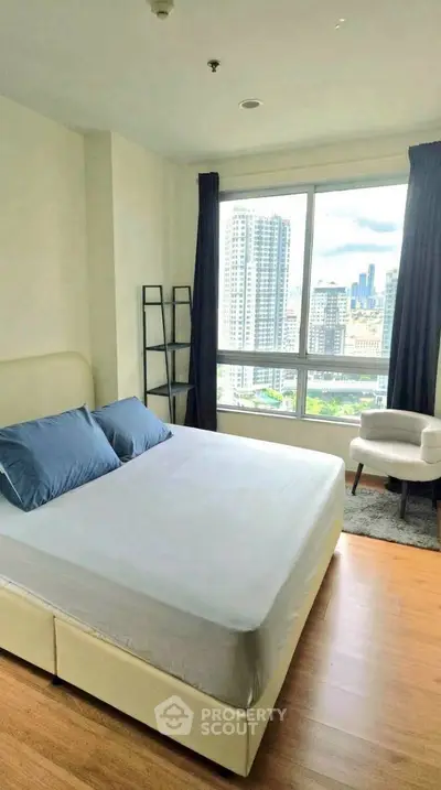 Modern bedroom with large window offering stunning city view in high-rise apartment.