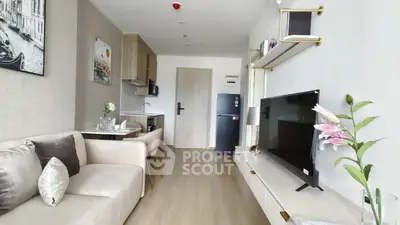 Modern living room with sleek furniture and open kitchen layout in a stylish apartment.