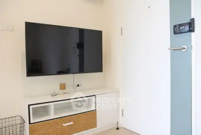 Modern living room with wall-mounted TV and stylish storage unit.