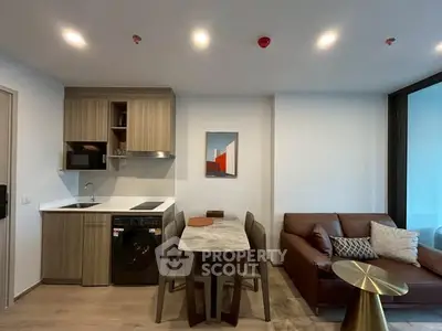 Modern open-plan living room with kitchen, featuring sleek appliances and stylish furniture.