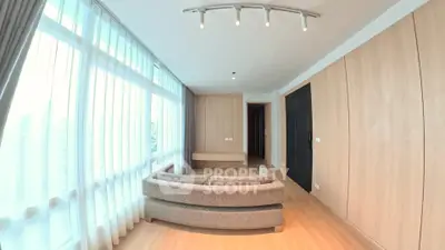 Spacious modern living room with large windows and elegant lighting