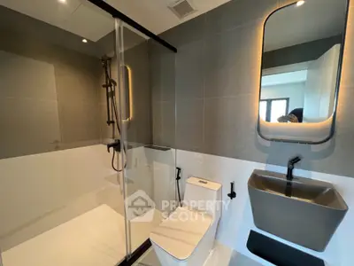 Modern bathroom with sleek shower and stylish fixtures in contemporary home.
