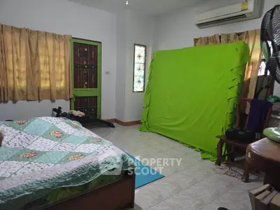 Spacious bedroom with unique decor and air conditioning, featuring a green screen setup for creative use.
