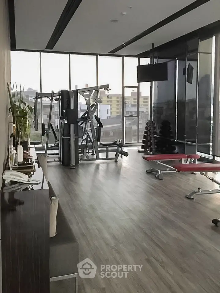 Modern gym with city view, featuring state-of-the-art equipment and sleek design for an upscale fitness experience.