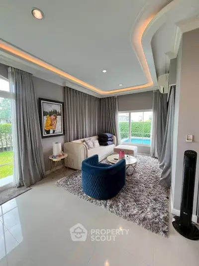 Luxurious living room with modern decor and pool view, featuring elegant furniture and ambient lighting.
