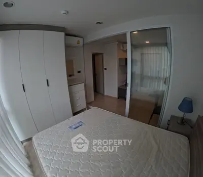 Modern bedroom with sliding glass doors and built-in wardrobe in stylish apartment